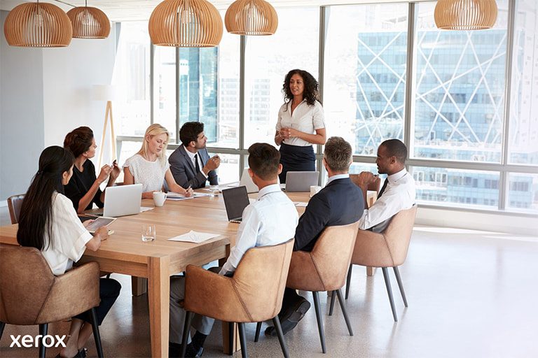 Eine Frau steht vor einer Gruppe, präsentiert selbstbewusst ihr Thema und interagiert während der Sitzung mit dem Publikum. Eine Frau steht vor einer Gruppe, präsentiert selbstbewusst ihr Thema und interagiert während der Sitzung mit dem Publikum.